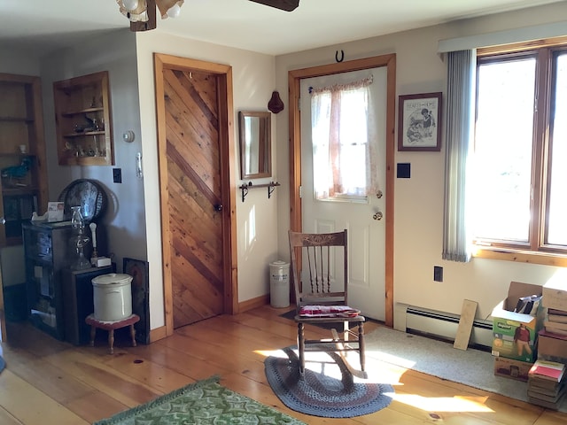 interior space with light hardwood / wood-style floors, baseboard heating, and ceiling fan