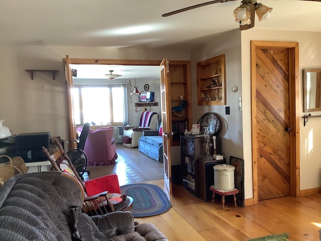 living room with light hardwood / wood-style floors and ceiling fan