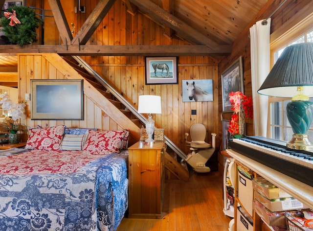 bedroom with wooden walls, vaulted ceiling, and hardwood / wood-style flooring