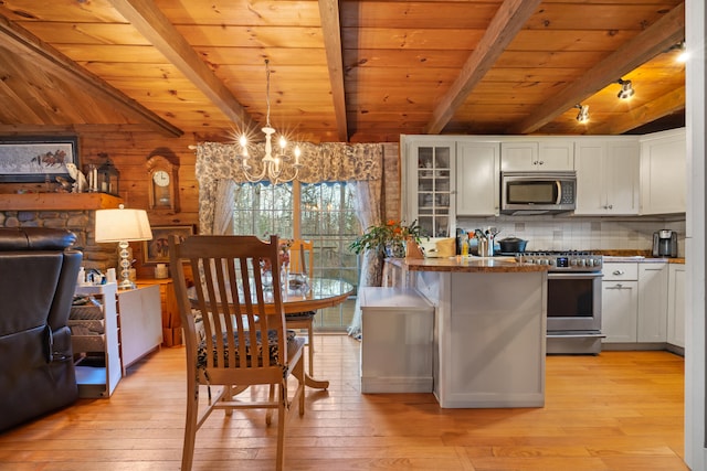 kitchen with wooden walls, light hardwood / wood-style floors, and appliances with stainless steel finishes