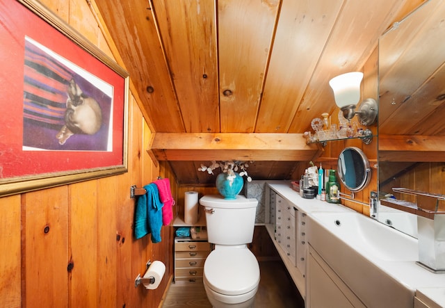 bathroom with vanity, wood walls, wooden ceiling, vaulted ceiling, and toilet