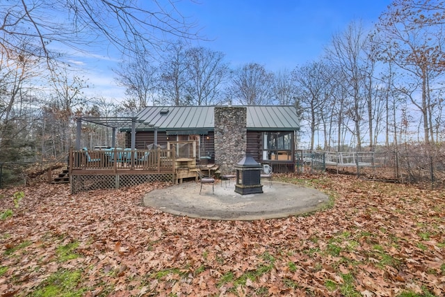 rear view of property featuring a deck and an outdoor fire pit