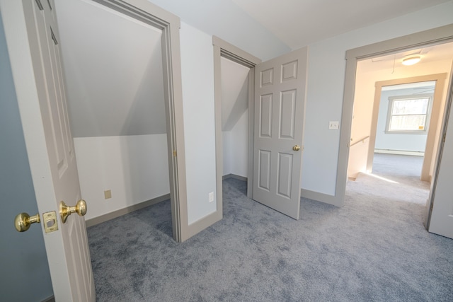 unfurnished bedroom featuring a baseboard radiator, vaulted ceiling, and light colored carpet