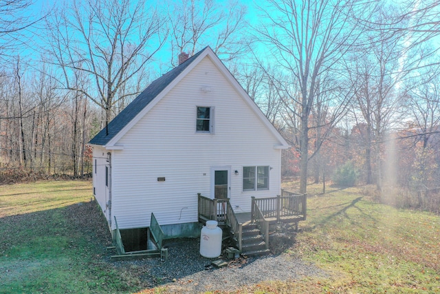 rear view of house with a wooden deck and a lawn