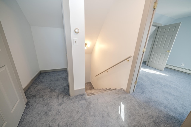 stairs featuring lofted ceiling, a baseboard heating unit, and carpet