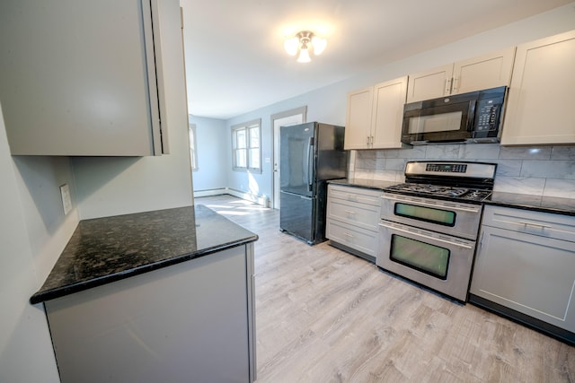 kitchen with backsplash, dark stone countertops, black appliances, light wood-type flooring, and white cabinetry