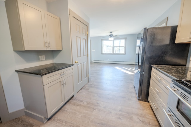 kitchen with a baseboard heating unit, ceiling fan, dark stone counters, light hardwood / wood-style floors, and stainless steel range