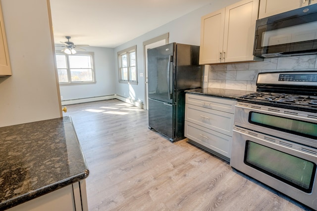 kitchen featuring black appliances, light hardwood / wood-style floors, ceiling fan, dark stone counters, and decorative backsplash