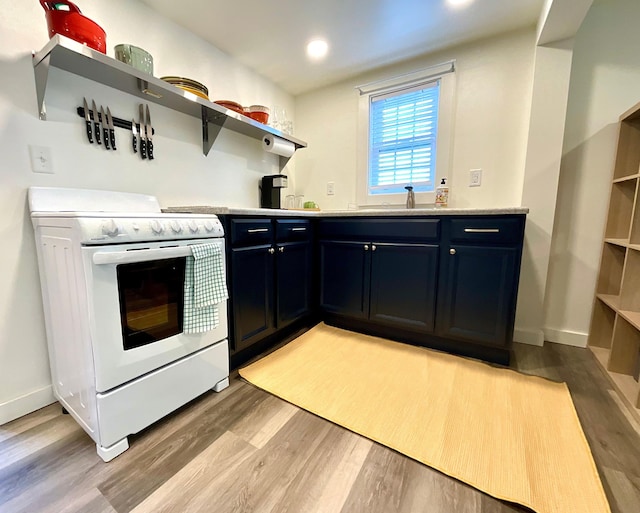 kitchen with light wood-type flooring, white range, blue cabinets, and sink