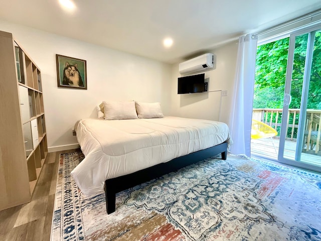 bedroom with access to exterior, light wood-type flooring, and an AC wall unit