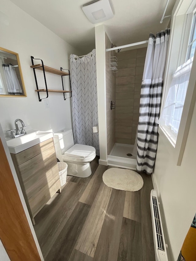 bathroom featuring a shower with shower curtain, hardwood / wood-style floors, vanity, and toilet