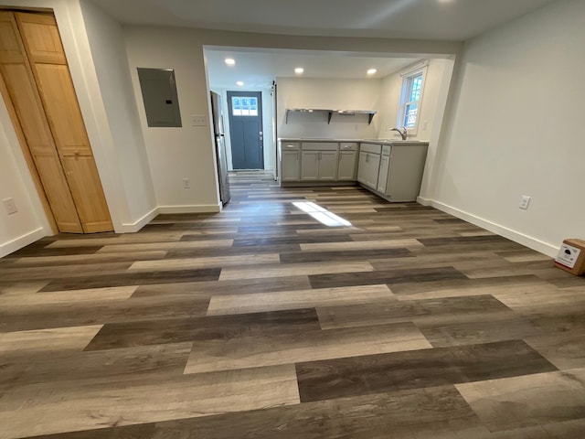 kitchen featuring dark wood-type flooring, electric panel, white cabinets, sink, and stainless steel refrigerator