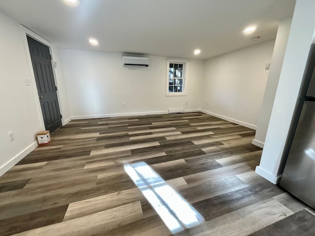 empty room featuring dark wood-type flooring and a wall unit AC