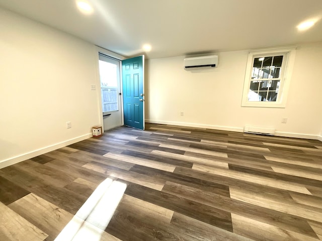 empty room featuring dark hardwood / wood-style flooring, an AC wall unit, and a baseboard radiator