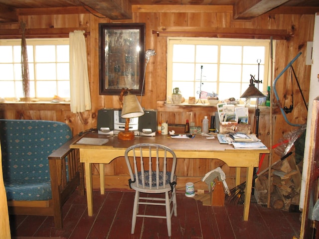 office featuring wood walls, beamed ceiling, built in desk, and plenty of natural light