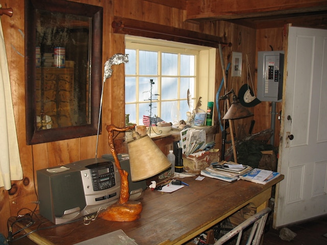 office area with wood walls and electric panel