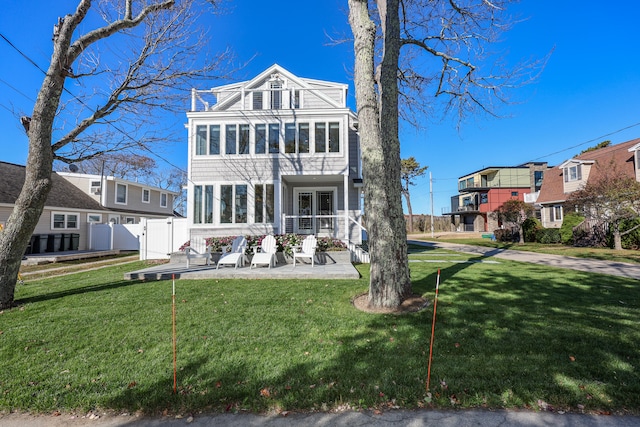 view of front of property with a front lawn, a patio area, and a sunroom