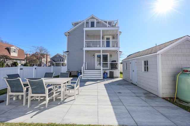 rear view of property featuring a patio area and a balcony