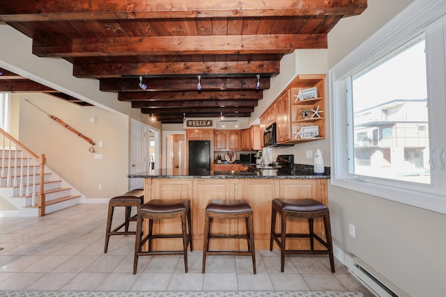 kitchen with kitchen peninsula, beamed ceiling, black appliances, and baseboard heating