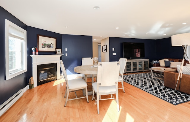 dining room with light hardwood / wood-style flooring and a baseboard heating unit