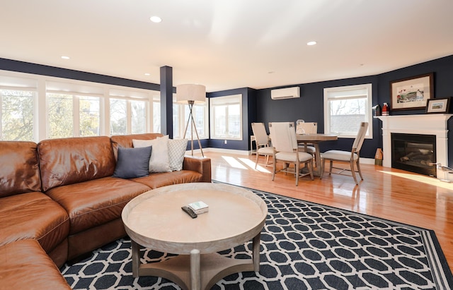 167 S Tibbetts Ave, Wells, ME 04090 - living area with wood finished floors, an AC wall unit, recessed lighting, a glass covered fireplace, and baseboards