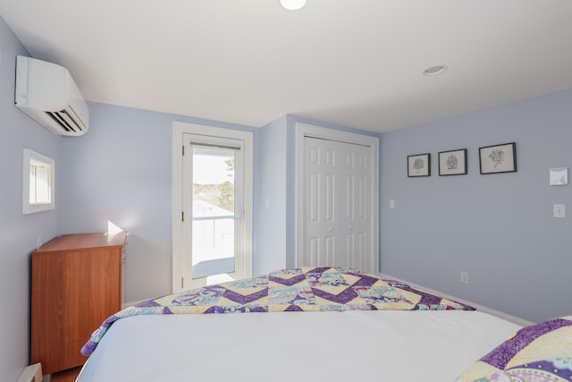 bedroom with a closet, a baseboard heating unit, and a wall mounted AC