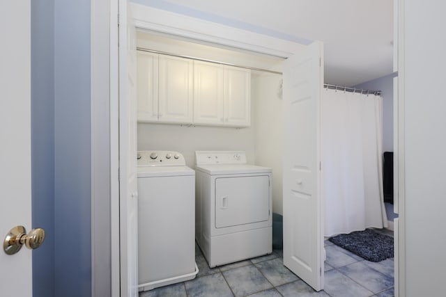 washroom featuring light tile patterned floors, separate washer and dryer, and cabinets