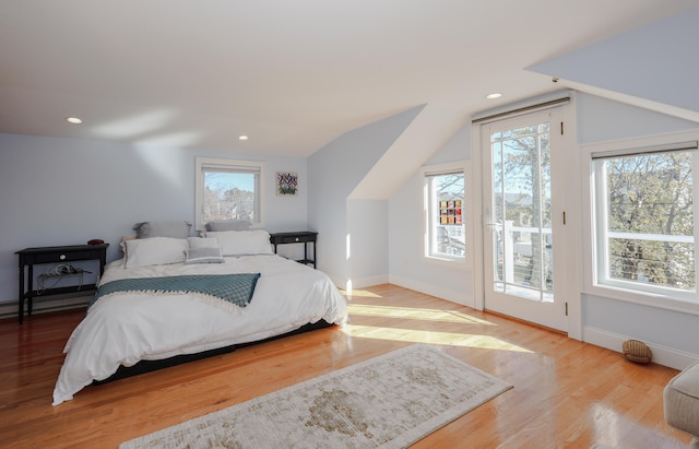 bedroom featuring light hardwood / wood-style floors, lofted ceiling, and access to exterior