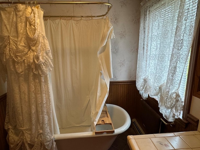 bathroom with shower / tub combo and wooden walls