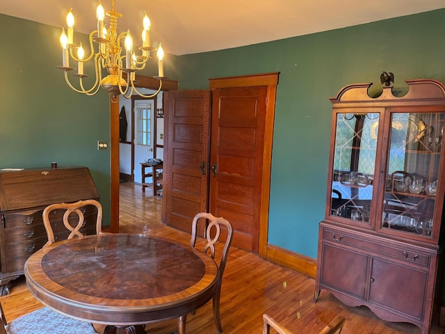 dining room featuring wood-type flooring and an inviting chandelier