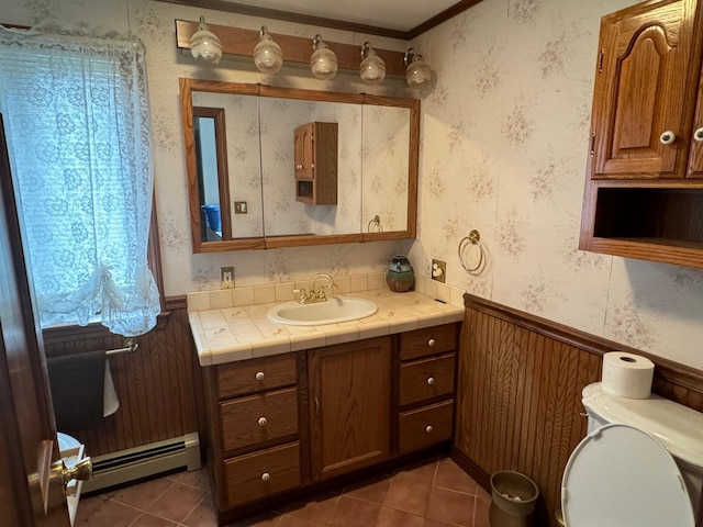 bathroom featuring vanity, a baseboard heating unit, crown molding, tile patterned floors, and toilet