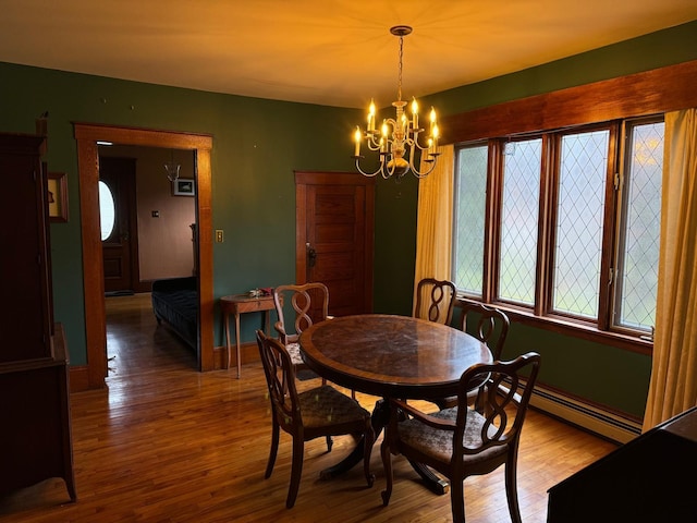 dining space with a notable chandelier, hardwood / wood-style flooring, and a baseboard radiator