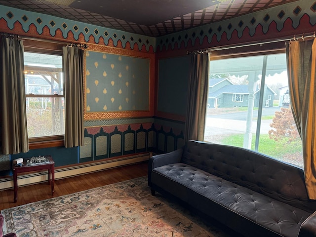 17 York St, Mars Hill, ME 04758 - living area featuring wallpapered walls, wood finished floors, and a baseboard heating unit