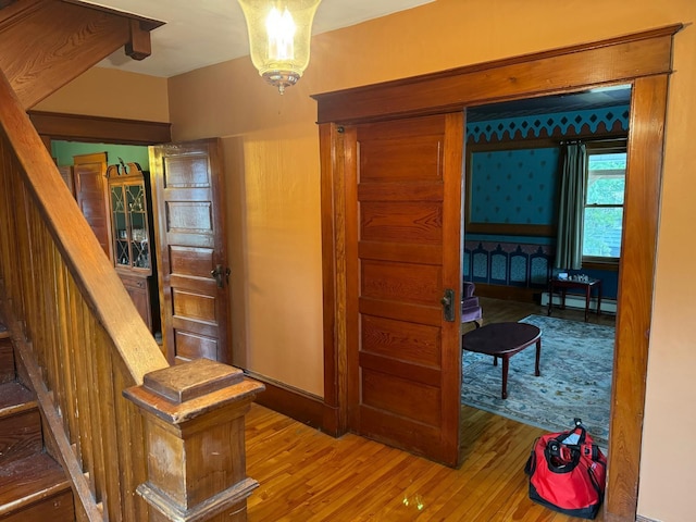 hall featuring hardwood / wood-style floors and a baseboard heating unit