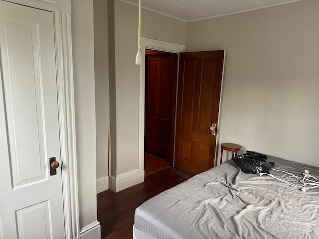 bedroom with dark hardwood / wood-style floors