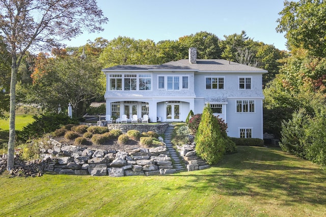 back of property featuring a lawn and french doors