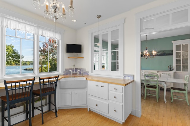 kitchen with sink, white cabinets, and decorative light fixtures