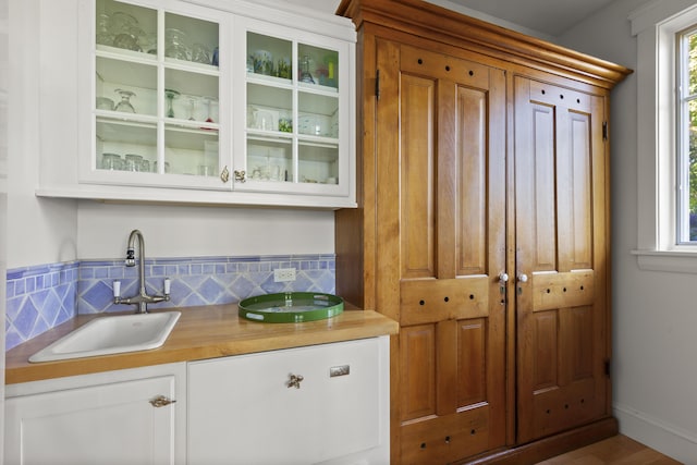 bar featuring white cabinetry and sink