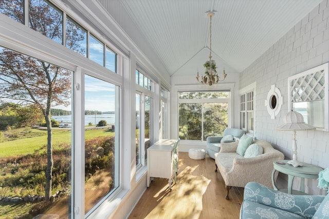 sunroom with a wealth of natural light, a water view, and vaulted ceiling