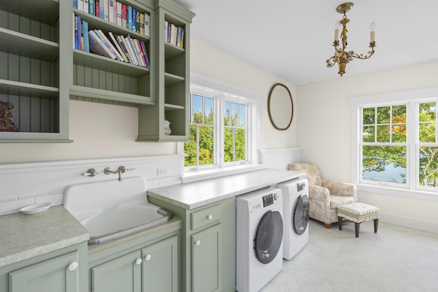 laundry room featuring cabinets, separate washer and dryer, a notable chandelier, and sink