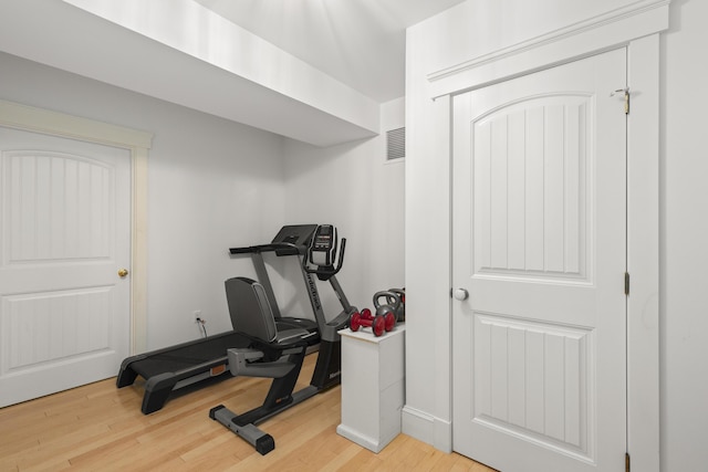 exercise room with wood-type flooring