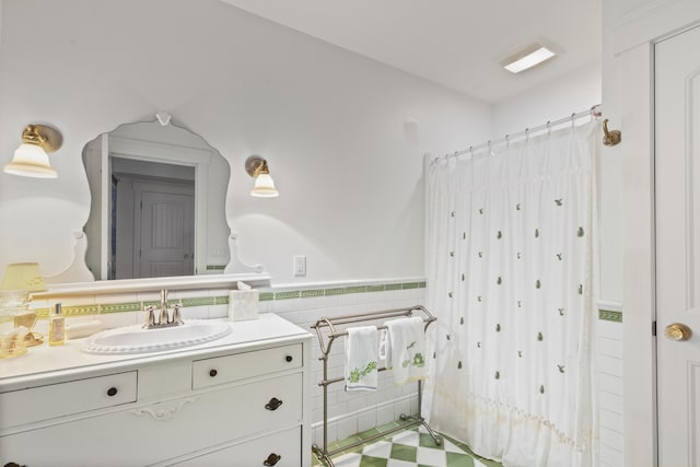 bathroom featuring vanity and tile walls