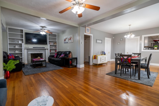 dining room with a textured ceiling, hardwood / wood-style flooring, and ceiling fan with notable chandelier