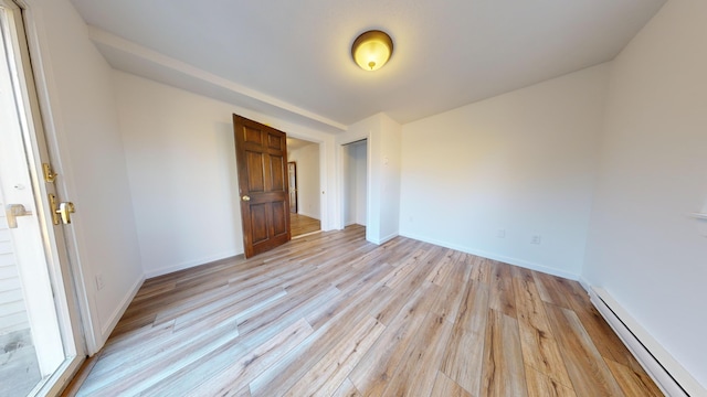 unfurnished bedroom featuring light hardwood / wood-style flooring and a baseboard radiator