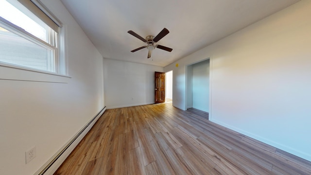 empty room with a baseboard heating unit, light wood-type flooring, and ceiling fan