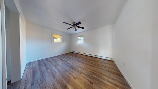 empty room featuring baseboard heating, light wood-type flooring, and ceiling fan