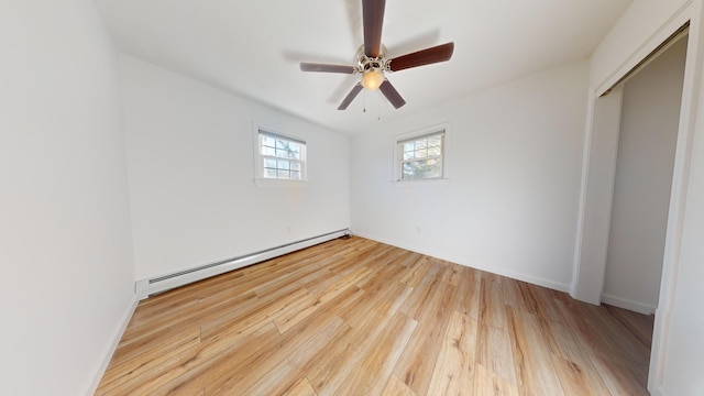 unfurnished bedroom featuring light hardwood / wood-style flooring, a closet, a baseboard radiator, and ceiling fan