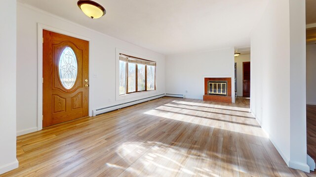 entrance foyer with light hardwood / wood-style flooring, a baseboard heating unit, and a fireplace