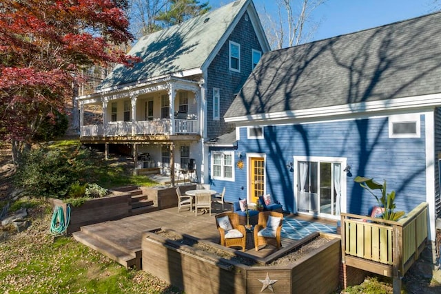 back of property with a wooden deck and a balcony