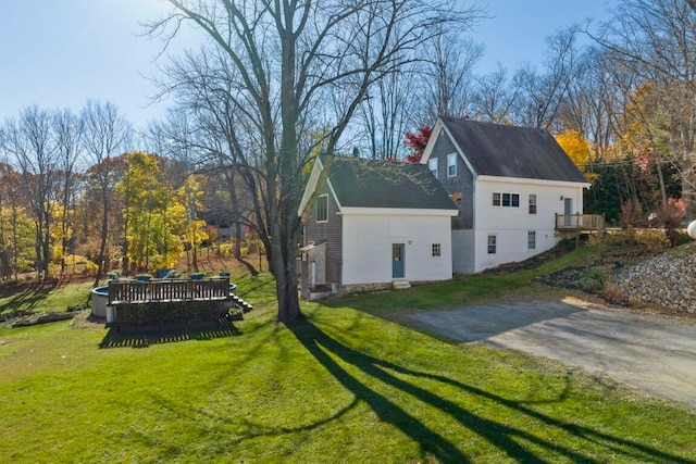 view of home's exterior featuring a wooden deck and a yard